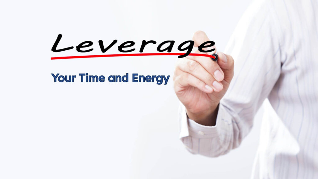 A man's hand writing the word Leverage on the window.