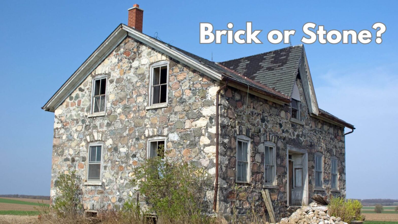 A stone house out in a meadow with a blue sky.The words Brick or Stone, above the roof of the house.