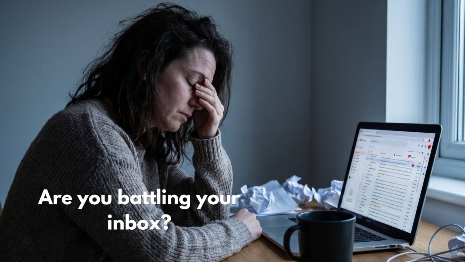 A woman sits at her desk with her head in her hand, eyes closed, looking overwhelmed. Her laptop shows a cluttered Gmail inbox overflowing with unread emails. Crumpled papers and a forgotten coffee mug sit beside her. Text on the image reads: Are you battling your inbox?